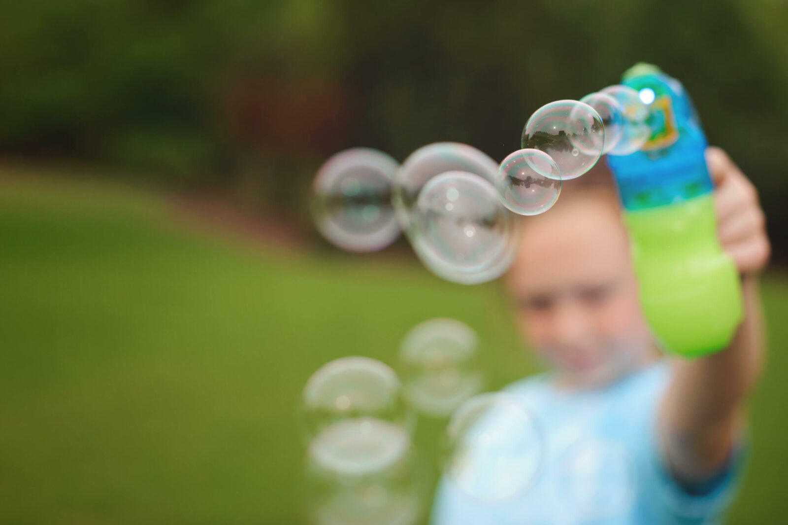 child blowing bubbles outside